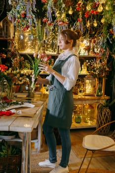 A woman in her florist shop collects bouquets of flowers. The concept of a small business. Bouquets of tulips for the holiday on March 8