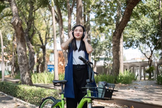 Asian businesswoman ride a bicycle in the city to work outside the city to reduce carbon emissions. Alternative transportation for green energy.