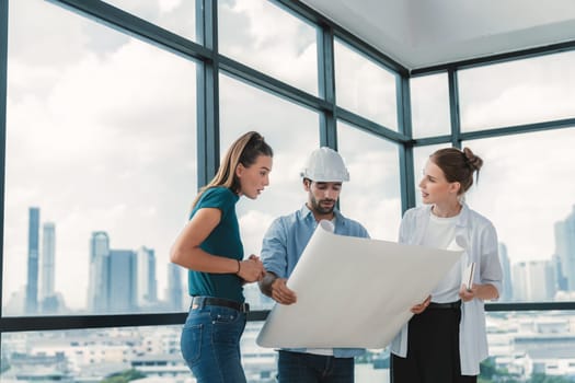 Group of architect engineer looking at project plan while brainstorming idea about building structure. Manager team discuss about building construction while standing near with city view. Tracery.