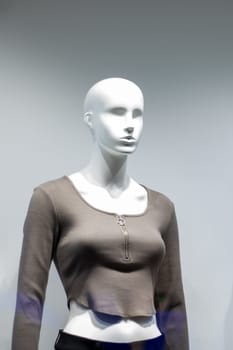 Female mannequin in gray jacket close up, copy space
