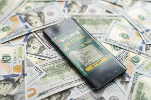 Smartphone with gambling mobile application with money close-up. Sport and betting concept. High quality photo