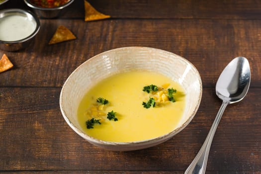 Top view of Italian corn soup on wooden table