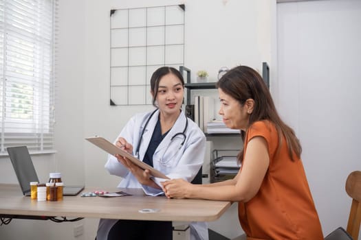 A female doctor and an elderly patient are giving advice on health care and the use of medicine to nourish the body..