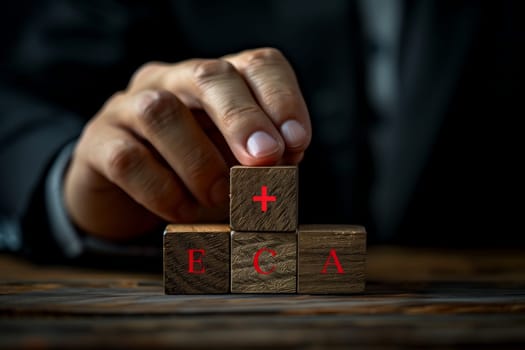 Using deft finger and thumb movements, the person skillfully stacks hardwood blocks in a game of indoor recreation. The wrist flicks with precision in the darkness