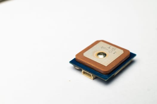 Waterproof GPS module with ceramic antenna on a white background in soft focus. Electronic components for hobby and assembly of FPV multicopters.