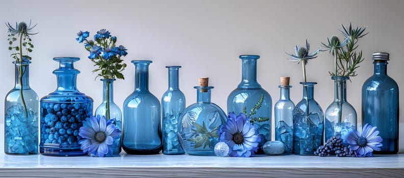 A lineup of electric blue glass bottles filled with colorful flowers displayed on a table