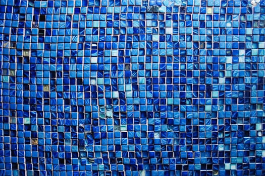 A blue mosaic tile wall with a blue and white swirl pattern. The tiles are blue and white and are arranged in a way that creates a sense of movement and depth