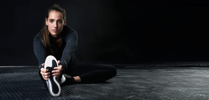 Portrait, fitness and stretching with sports woman on space for start of health or workout routine. Exercise, floor and warm up with confident young athlete training in studio to improve performance.