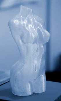 Woman body printed on 3D printer. Woman figure shaped object created 3D printer from plastic. Detailed prototype woman body printed on 3D printer close-up. New modern additive 3D printing technologies