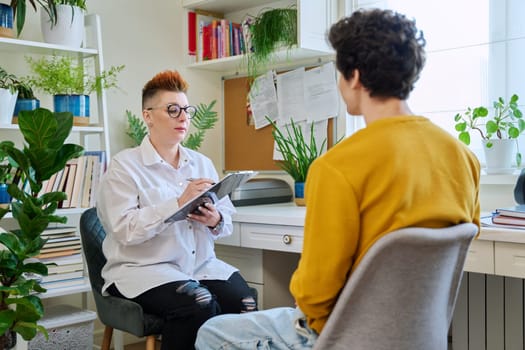 Female professional psychologist mental therapist working with young guy in office. Social worker counselor psychotherapist helping patient with difficulties stress depression. Psychology psychotherapy