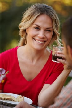 Woman, happy or smiling with cup on picnic date with partner for love, romance and memories together. Person, drinking and eating healthy meal with boyfriend for conversation, bonding or relationship.