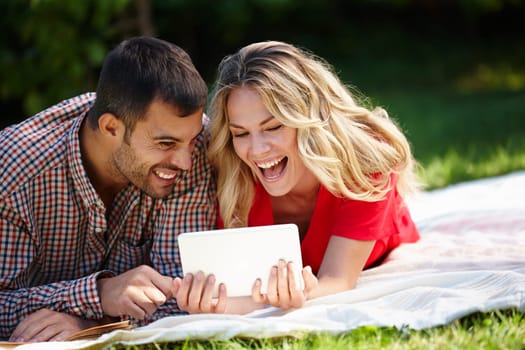 Couple, blanket and tablet to relax on grass, internet and commitment to relationship in outdoor nature. Happy people, bonding and streaming for marriage, romance and online on vacation or holiday.