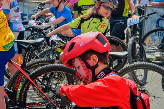 Hustopece, The Czech Republic - April 29, 2018: Traditional bike competition Bicycle for life . Racers waiting to start. Young cyclist has make-up like Spiderman .