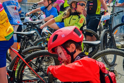 Hustopece, The Czech Republic - April 29, 2018: Traditional bike competition Bicycle for life . Racers waiting to start. Young cyclist has make-up like Spiderman .