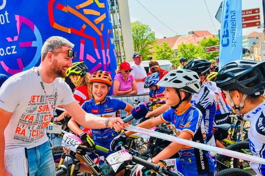 Hustopece, The Czech Republic - April 29, 2018: Traditional bike competition Bicycle for life . Racers waiting to start. Reporter of Czech television asking young cyclist.