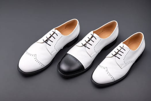 The image shows a pair of white shoes with black leather soles and laces on a gray background.
