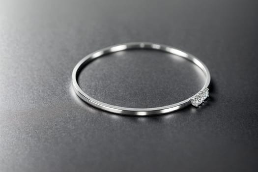 The image is a silver bangle with a small diamond in the center.
