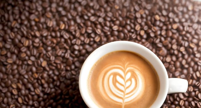 The image shows a cup of coffee with a heart shape made out of foam on top.