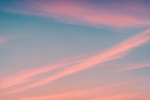 The image is a pink and purple sky with clouds and a sunset in the background.