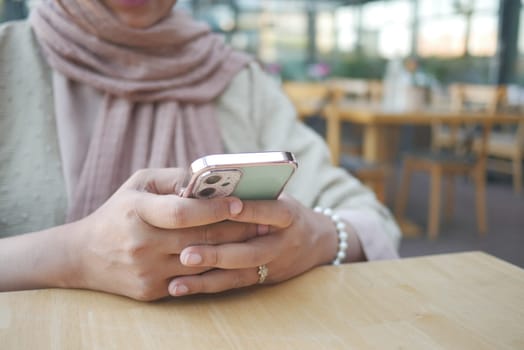 women hand holding smart phone sitting on cafe .