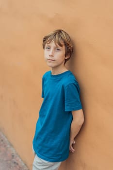 Cheerful teenage boy with joyful smile, happy male kid dressed in shirt standing against bright yellow background, exuding confidence and happiness, copy space.