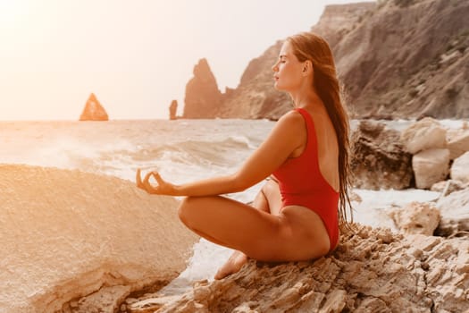 Woman sea yoga. Back view of free calm happy satisfied woman with long hair standing on top rock with yoga position against of sky by the sea. Healthy lifestyle outdoors in nature, fitness concept.