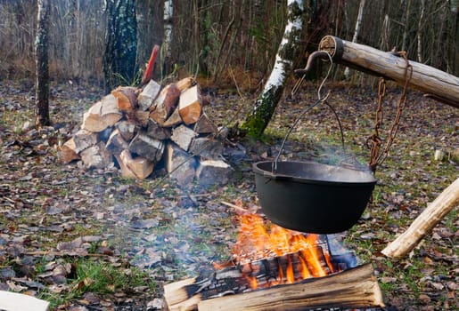 Cooking Fish Soup On The Fire. Touristic metal bowler pot. Cooking at the campsite, picnic, outdoor recreation.