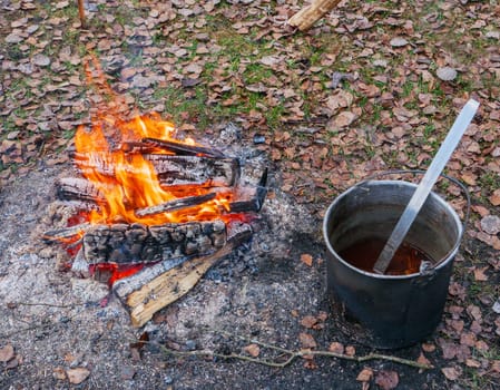 Fish soup boils in cauldron at the stake. Hot fresh food to prepare in the woods. camping kitchen. .traveling kitchen