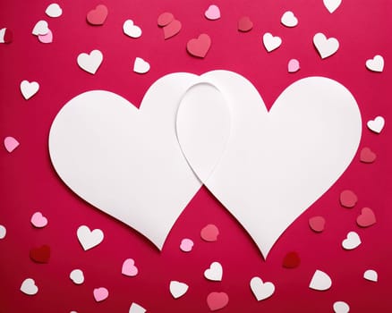 The image is a pink heart with two white hearts in the center, surrounded by confetti.