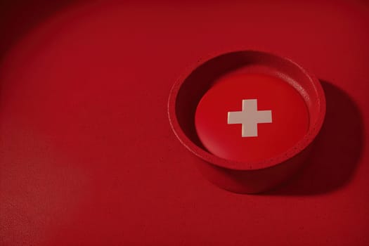 The image is a red container with a white cross on it.