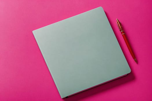 The image is a blank notebook with a pink pen on top of it.