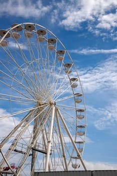 A part of Ferris wheel against a cloudy blue sky
