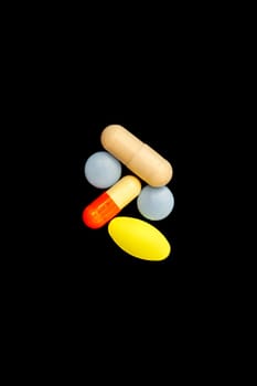 Different colorful medications and pills, isolated on black