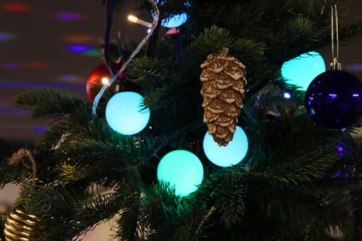 Indoor Christmas tree decorated with balls, stars, garlands, pine cones and garlands. New Year's toys..