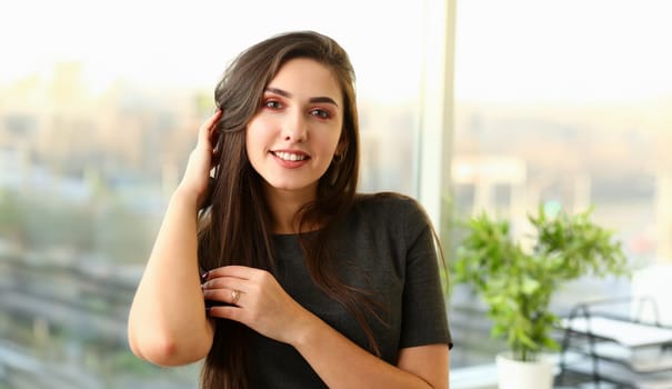 Beautiful european woman portrait. Worth office background and smiling beauty fashion style curly hair with white strands view of the eye in the camera