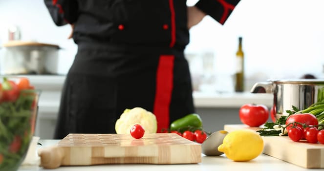 Cherry tomatoes lie on a cutting board in kitchen against backdrop of greenery healthy eating concept