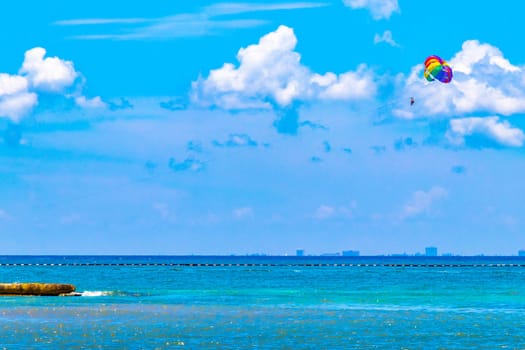 Tropical mexican caribbean beach and sea with people sun loungers parasols resort turquoise water and waves in Playa del Carmen Quintana Roo Mexico.