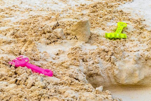 Beach toys toy colorful bucket and shovel on white sand in Playa del Carmen Quintana Roo Mexico.