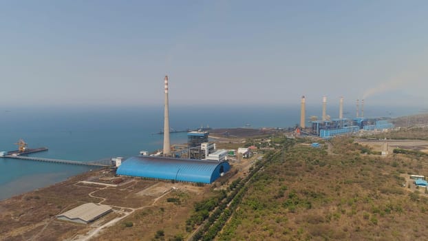 power station by sea with smoking pipes, paiton java, indonesia. aerial view power plant in asia.