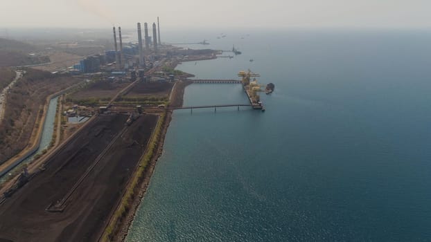 power station by sea with smoking pipes, paiton java, indonesia. aerial view power plant in asia.