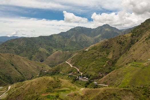 Mountains covered rainforest, trees and blue sky with clouds. Philippines.