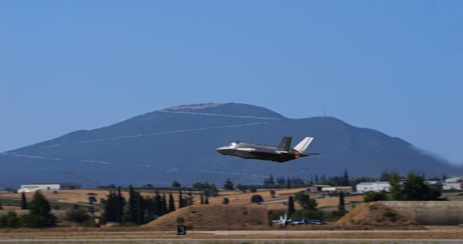 Athens Greece September 3 2023: US air force f-35 lightning ii jet flying with a mountainous landscape in the background. Space for text.