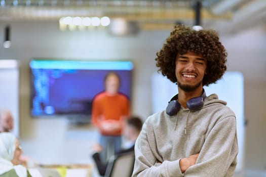 In a modern office environment, an African American young entrepreneur with headphones engages in work, while in the background, his dedicated colleagues exemplify teamwork and collaboration, encapsulating the essence of contemporary corporate success.