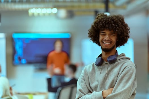 In a modern office environment, an African American young entrepreneur with headphones engages in work, while in the background, his dedicated colleagues exemplify teamwork and collaboration, encapsulating the essence of contemporary corporate success.