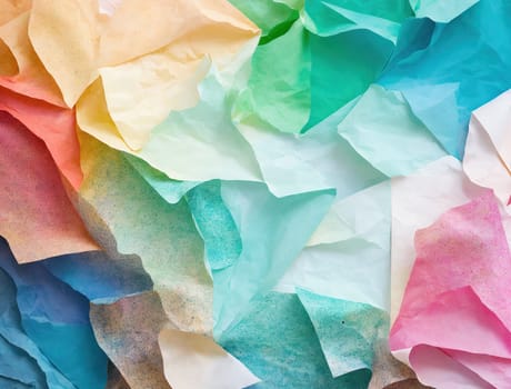 The image is a colorful, abstract background made up of crumpled paper.