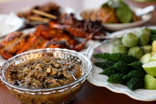 Local Thai food for people in the central region of Thailand. Spicy fermented fish chili paste dipping with fresh vegetable and grilled chicken.