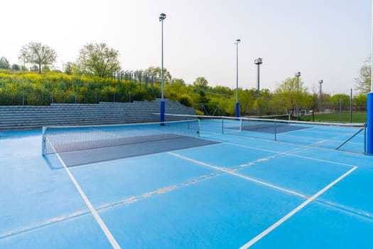 Empty new blue outdoors pickletball and tennis courts in a sunny day