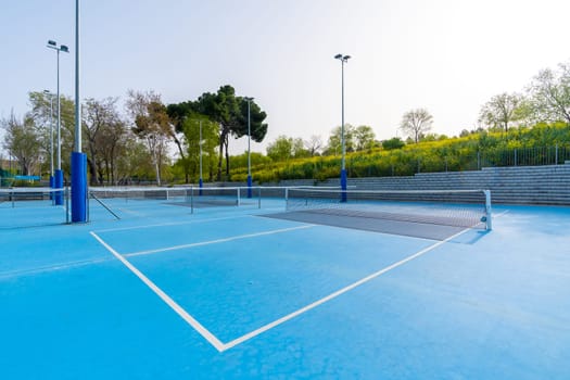 Sunny day in pickleball outdoors blue court with no people around