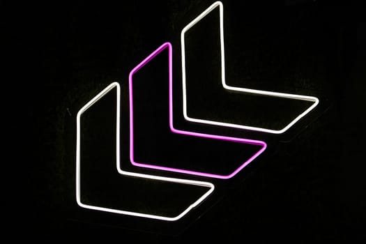 neon direction sign on black background, direction