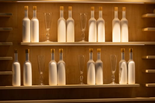 shelf with bottles and glasses in beautiful lighting, interior
